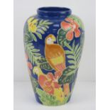 A glazed vase having tropical foliage and parrots upon, 27.5cm high.