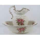 A wash jug and bowl, cream ground with pink rose pattern upon.