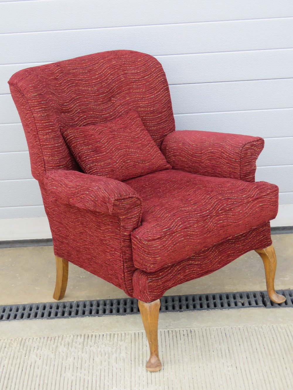 A vintage arm chair re-upholstered in contemporary red fabric, with cushion,