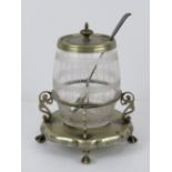 A barrel shaped glass condiment pot having silver plated lid with holly design upon and silver