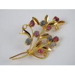 A gilt metal floral brooch set with ruby and sapphire cabachons, no apparent hallmarks,