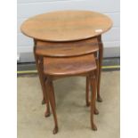 A nest of three 20th century walnut tables raised over slender taping legs, 60,