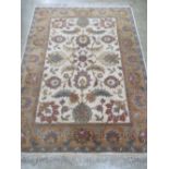 A good heavy woollen and silk floral rug in muted greens and browns measuring 212 x 156cm.