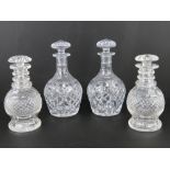 Two pairs of lidded cut glass decanters standing 24cm and 21cm high respectively.