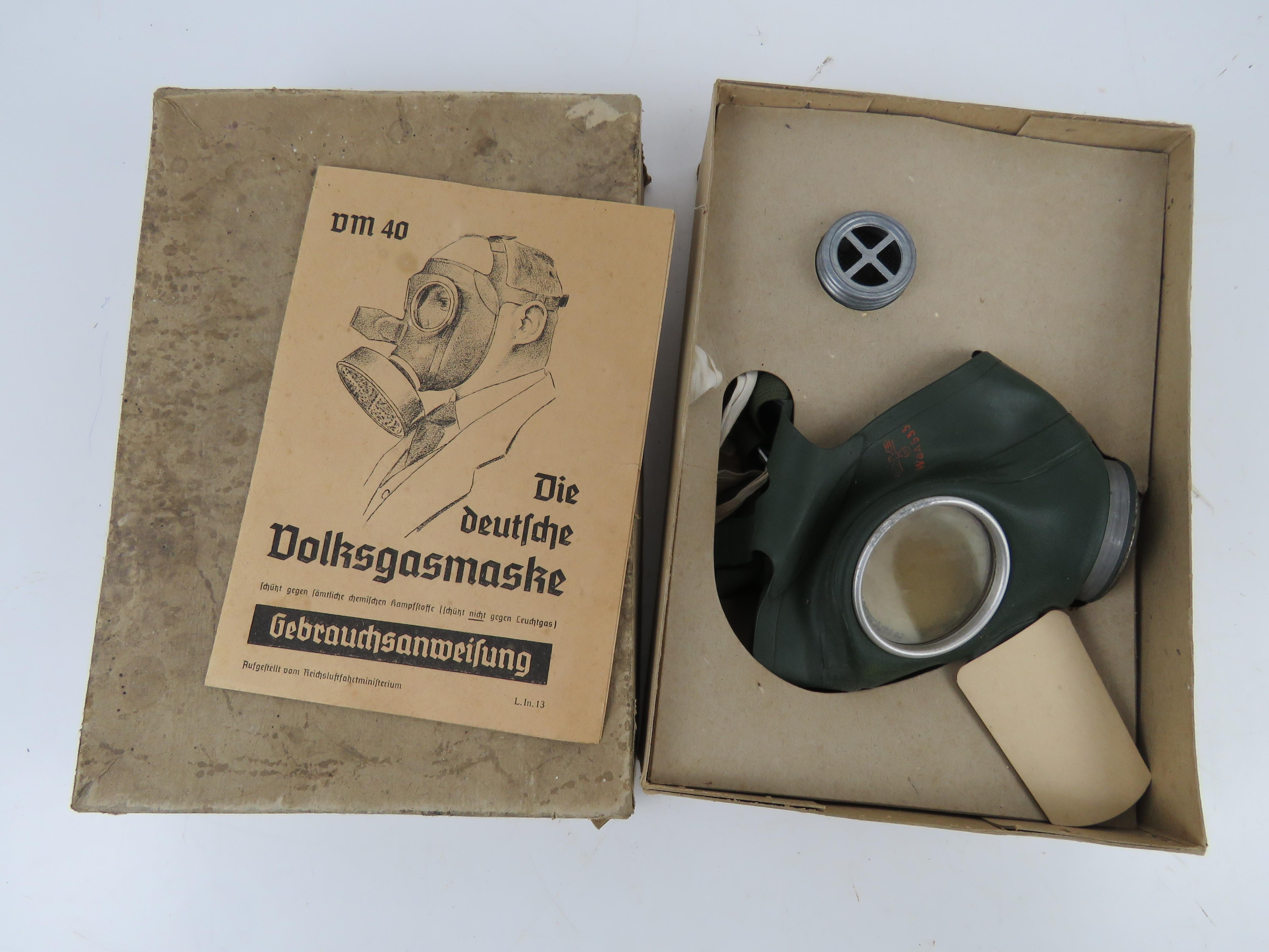 A WWII German civilian gas mask and filter in box with instructions, having German marks.