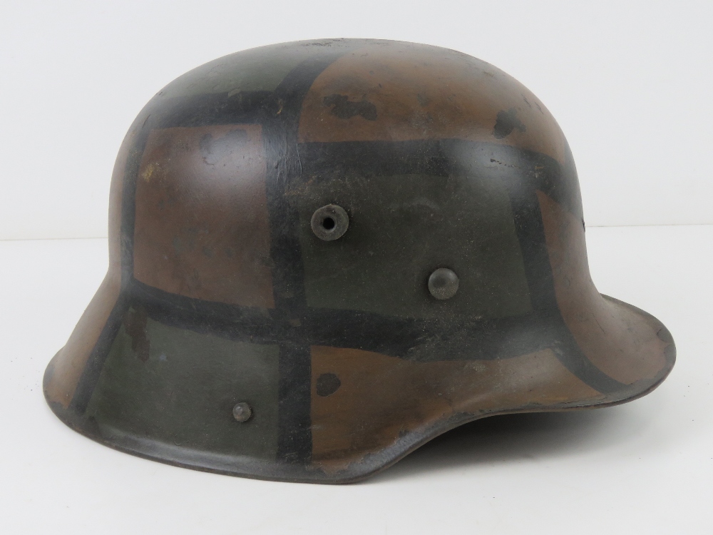 A reproduction WWI German M16 helmet with liner having camo paint.