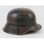 A reproduction WWI German M16 helmet with liner having camo paint.