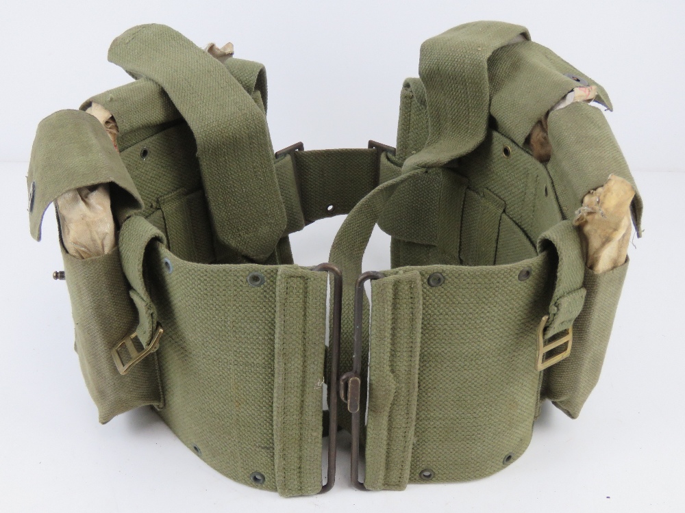 A green canvas BAR belt having four BAR magazines within.