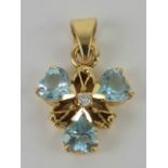 A blue topaz and diamond floral pendant having central round cut diamond with three heart shaped