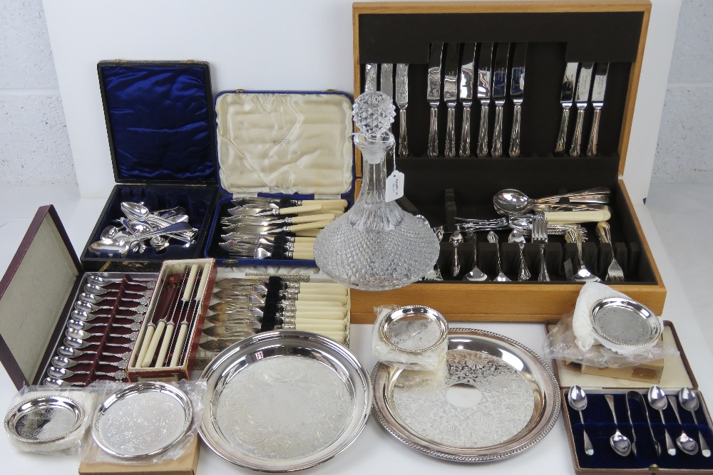 A large quantity of assorted silver plated and other cutlery including part set in wooden canteen,