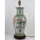 An Oriental vase converted for use as a table lamp, raised over wooden base,