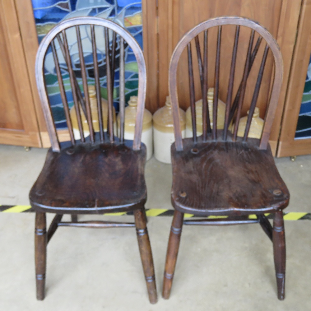A pair of hoop back spindle turned elm seated chairs.