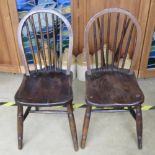 A pair of hoop back spindle turned elm seated chairs.