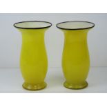 A pair of overlaid glass vases having yellow ground with white interior and black rim,