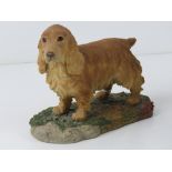 A figurine of a Golden Cocker Spaniel bearing label for Arista Designs Hawick Scotland and signed P.