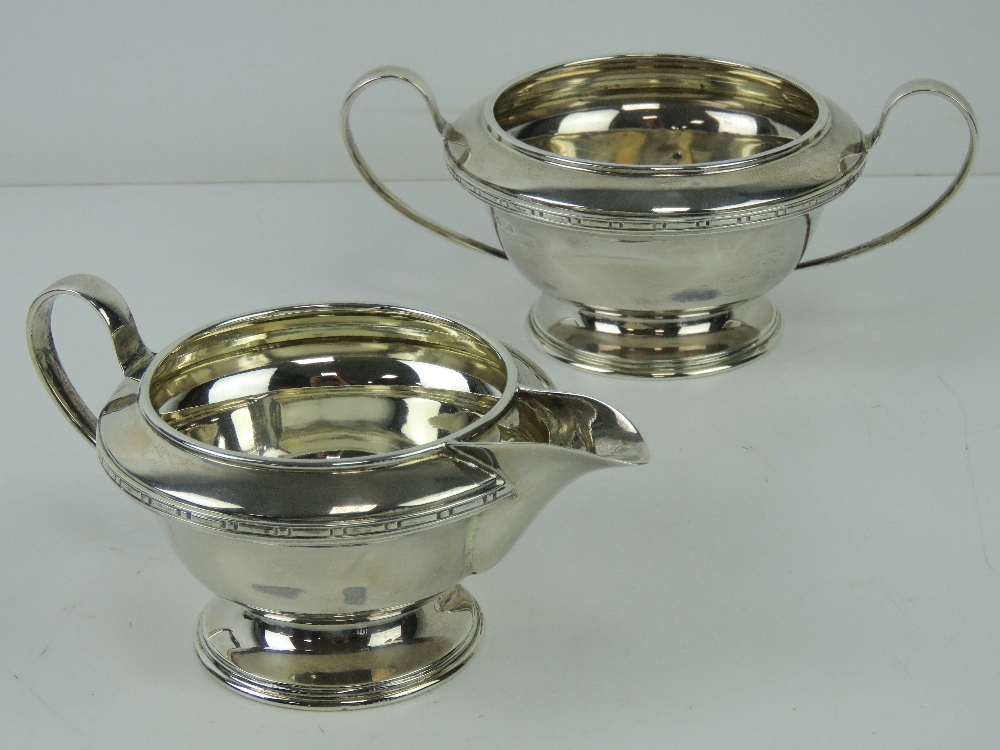 An HM silver sugar bowl and cream jug each raised over single foot and hallmarked Sheffield 1933