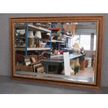 A contemporary gilt framed bevelled edge wall mirror, 104 x 75cm.