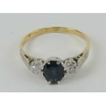 An 18ct gold sapphire and diamond ring, the central blue oval cut sapphire approx 0.