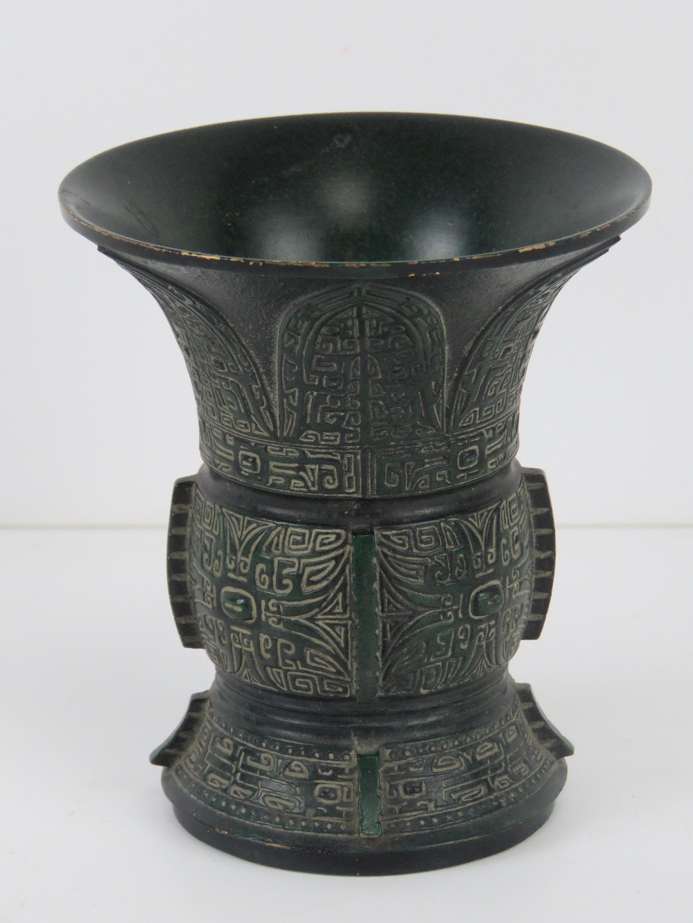 A short green ground brass vase having geometric carved pattern upon, character mark to base, 10.