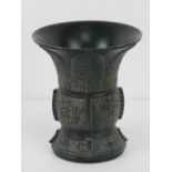 A short green ground brass vase having geometric carved pattern upon, character mark to base, 10.