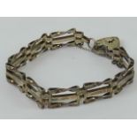 A silver three-bar gate link bracelet having London hallmark to heart padlock clasp, 10.1g.