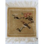 A hand knotted miniature carpet panel having bird and tree blossom upon, 32 x 30cm.