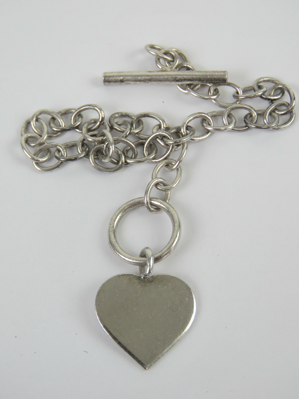 A HM silver charm bracelet having T-bar clasp with Heart charm upon, 19cm in length,