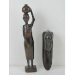 A carved African hardwood figurine of a woman standing 31cm high,