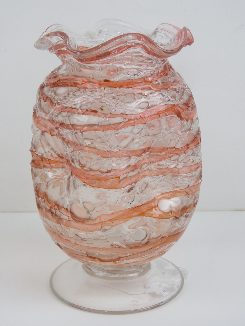 A dimpled and footed glass vase having handkerchief neck and standing 19cm high.