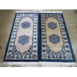 A pair of Chinese woollen rug, one blue and cream ground one beige and blue,