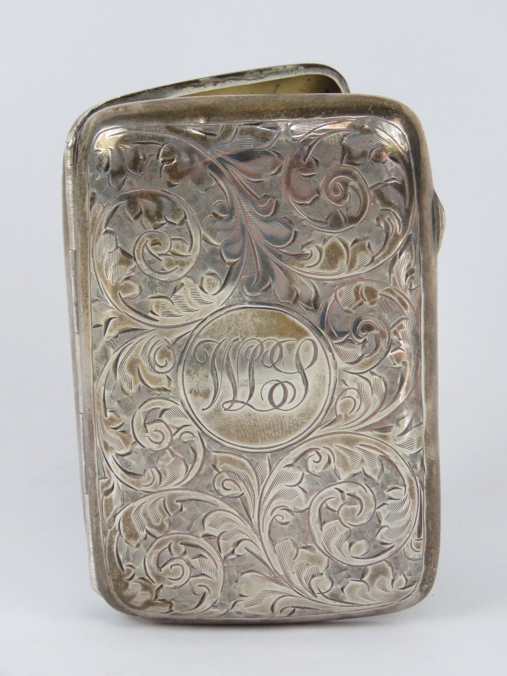 A HM silver cigarette case having scrolling foliage engraved upon and gilded interior,