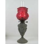 A cranberry glass and spelter Victorian duplex oil lamp comprising shade (slightly a/f),