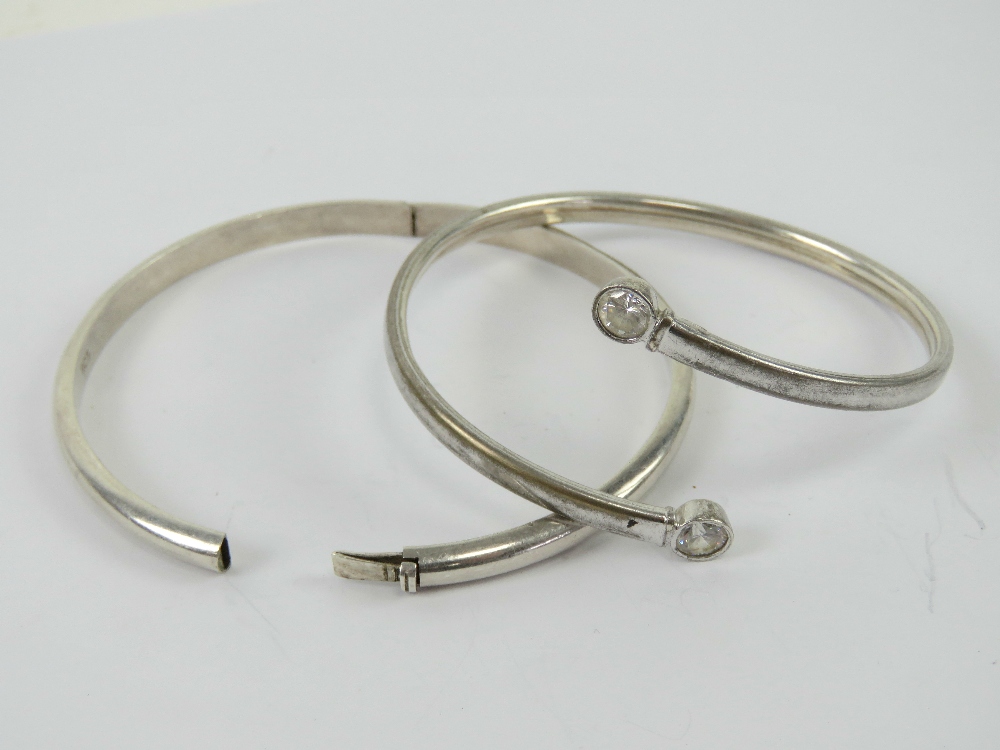 A silver bangle having white stone terminals, stamped 925.