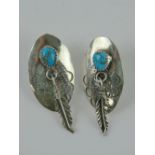 A pair of Native American sterling silver and turquoise earrings having feather charm upon,