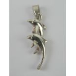 A silver pendant in the form of two leaping dolphins, stamped 925, measuring 3cm inc bale.