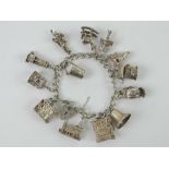 A HM silver charm bracelet with a quantity of large size charms upon including; miners lamp,