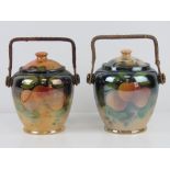 Two ceramic pearlescent wafer / biscuit barrels each with wicker handle and fruit design upon.