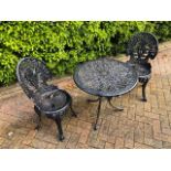 A cafe patio set comprising twin painted aluminium Victorian style chairs and matching circular