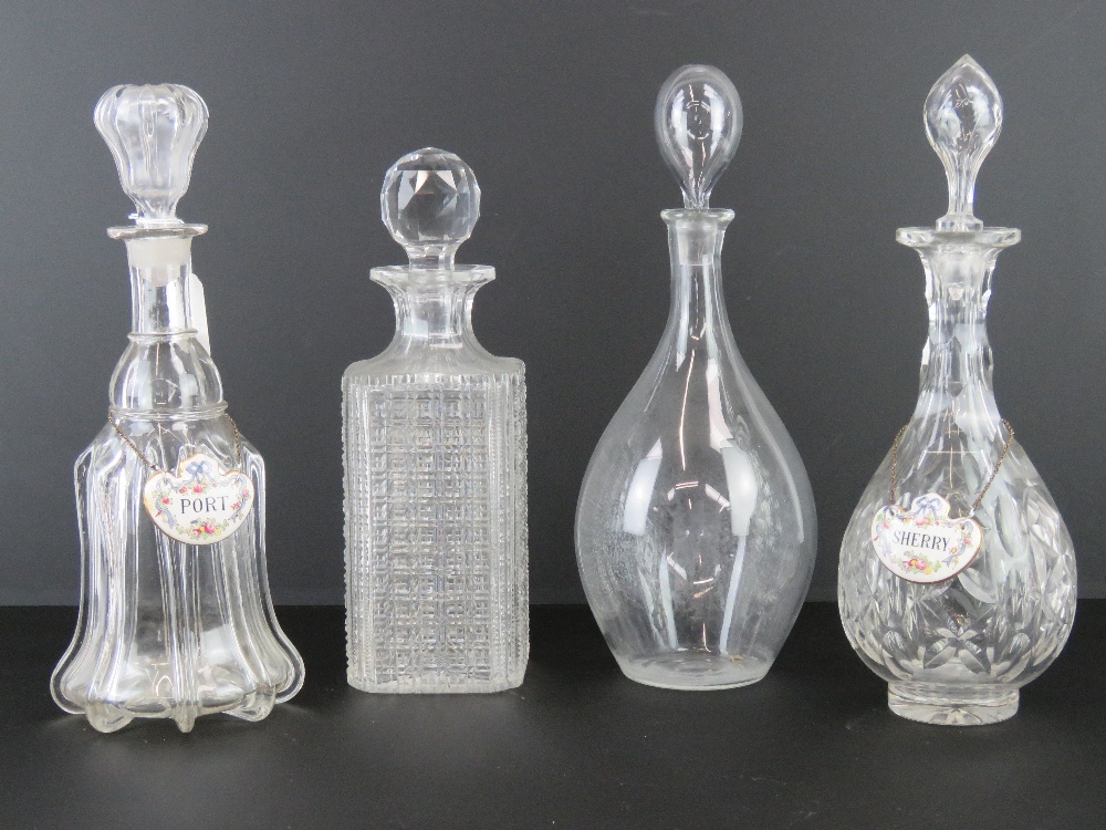 Four assorted cut glass decanters. Together with two ceramic labels for Port and Sherry.