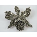 A vintage silver and marcasite brooch in the form of an orchid, 5cm wide, 26.6g.