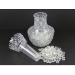 A lead crystal heavy cut glass two sectional lily vase, containing a quantity of glass beads,