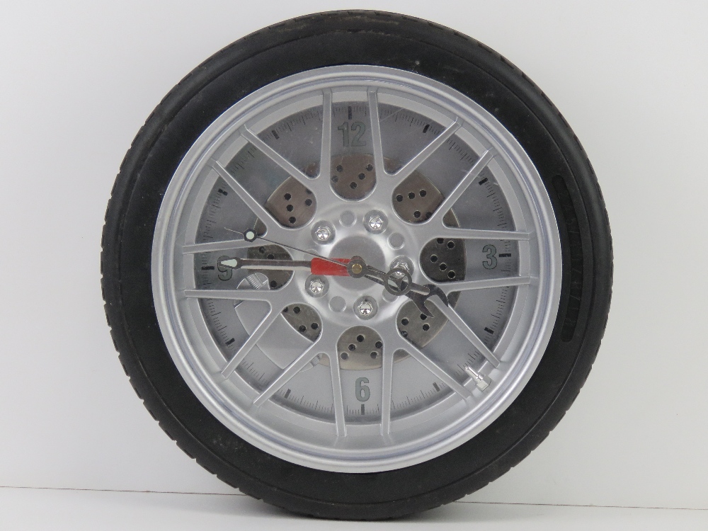 A contemporary wall clock in the form of a wheel having 'alloy', brake disc and caliper.