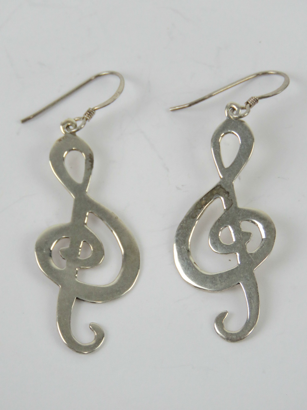 A pair of earrings in the form of treble