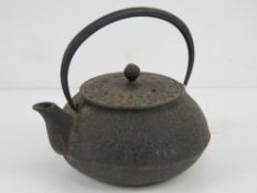 An oriental cast iron teapot having rais