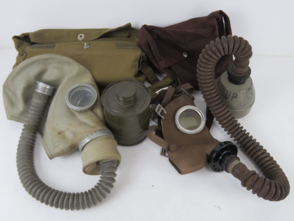 A Czech M-52 gas mask with filter in bag. Together with a Belgium L702 gas mask with filter in bag.