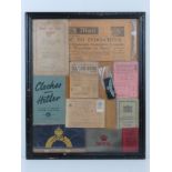 A framed montage of WWII items inc rations books, identity card, driving licence, arm bands,