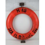 A HMS Marlborough life preserver ring having mounting hooks attached.