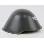 A late 20thC East German helmet marked within III/57, having chin strap and liner.