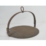 An antique wrought iron fireside skillet having hoop top with eyelet, 30cm dia.