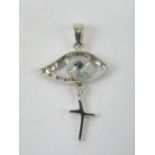 A 14ct white gold pendant in the form of an eye with cross suspended below, stamped 585 14k,